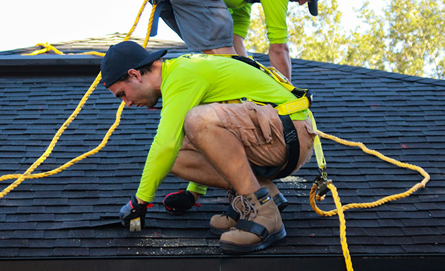 roofing professional repairing loose shingles on a roof